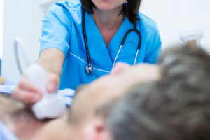 Male getting ultrasound of a thyroid from doctor