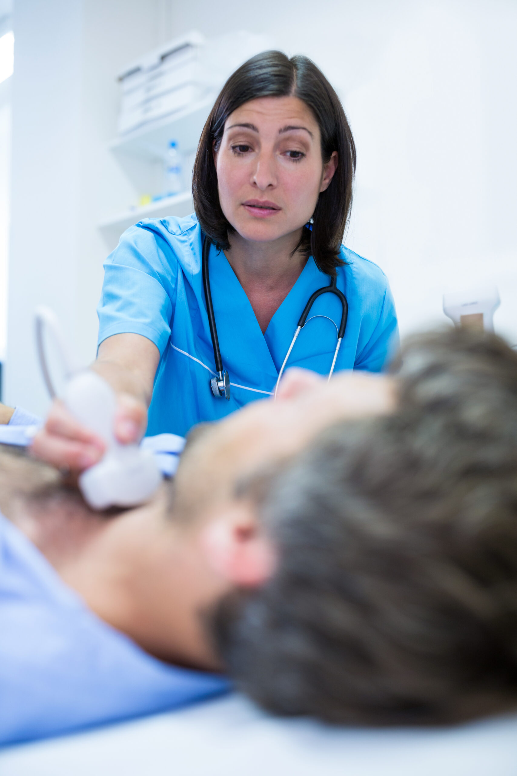 Male getting ultrasound of a thyroid from doctor Male getting ultrasound of a thyroid from doctor in hospital